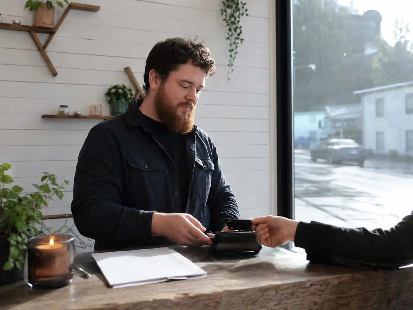 Business owner taking an online booking and deposit at the counter