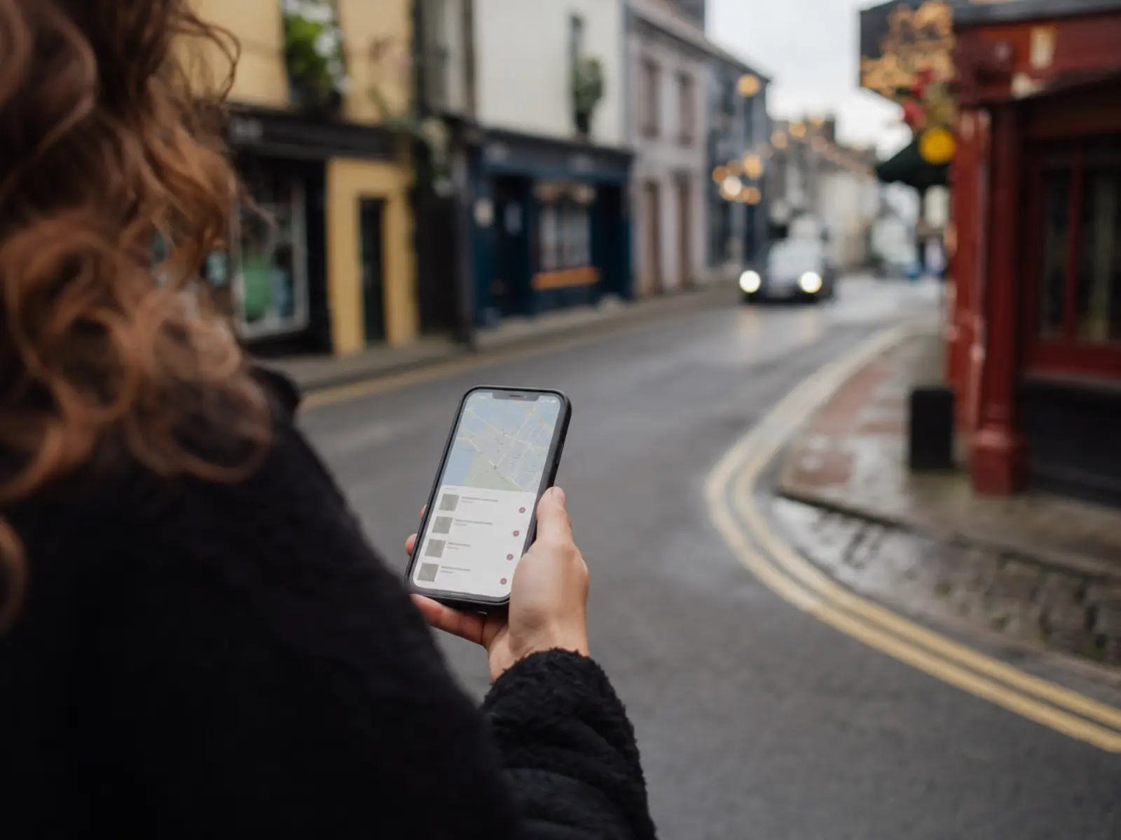 Someone finding a local business on their phone on an Irish street