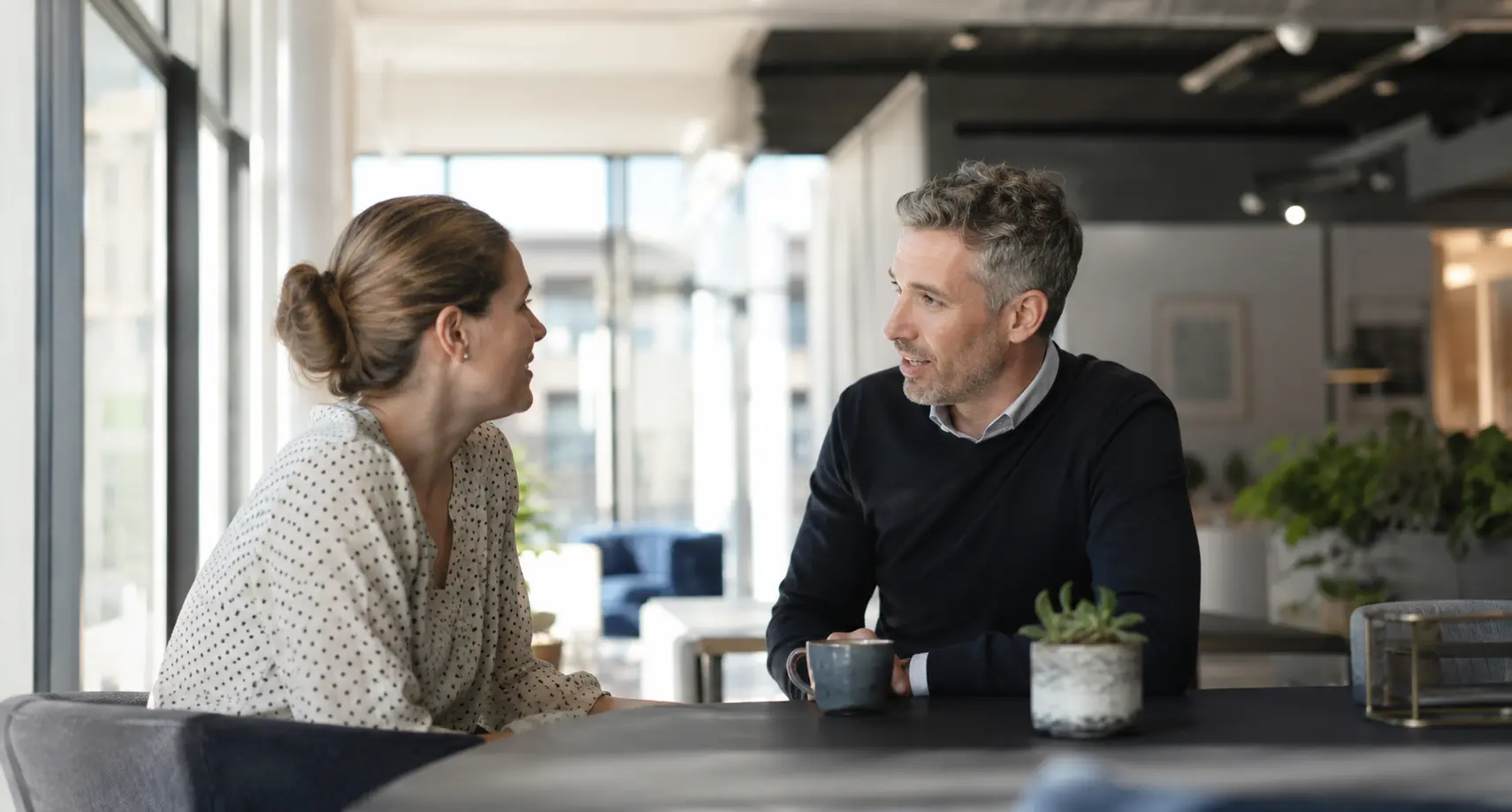 Two people having a straight, honest conversation across a table
