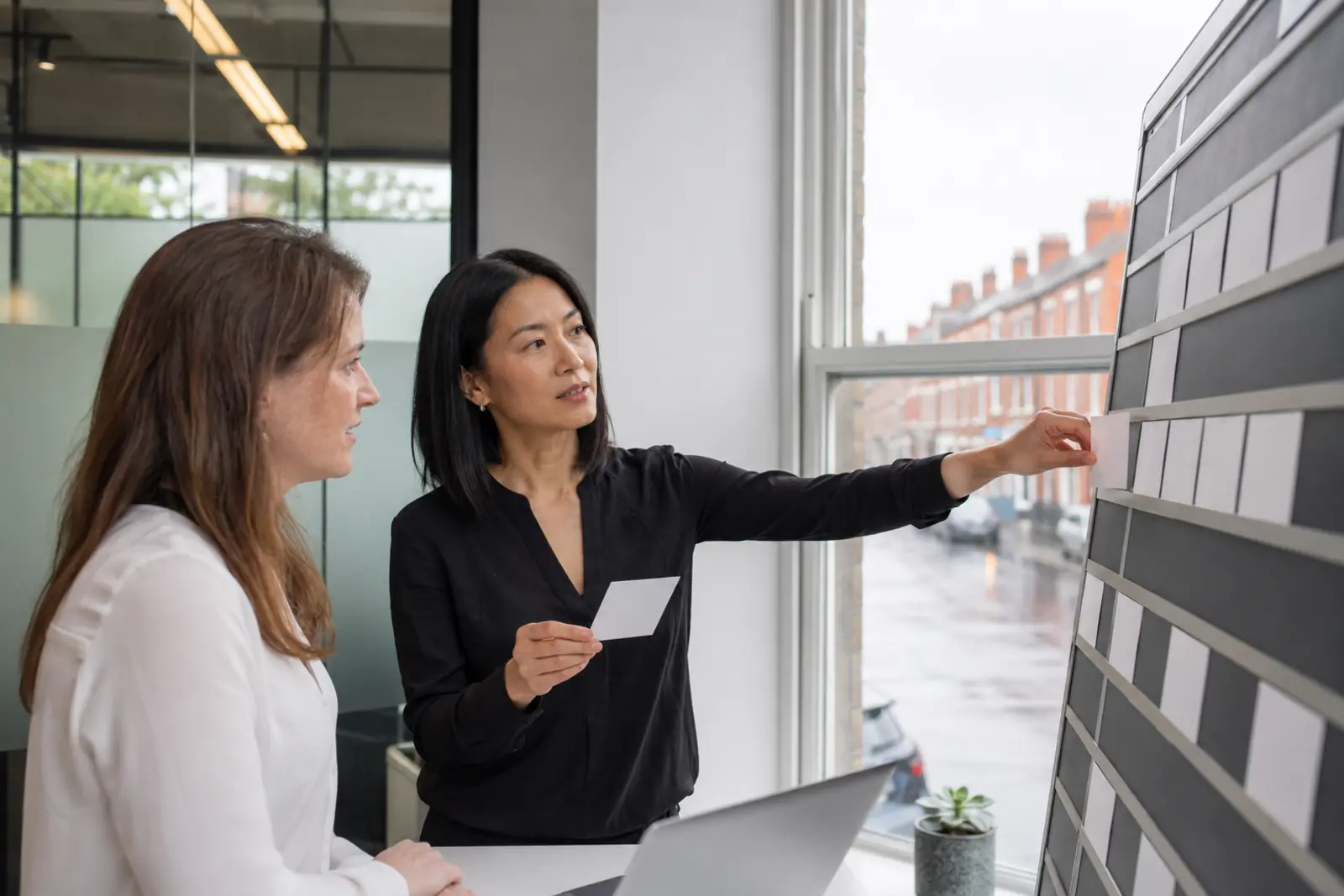 Two mortgage advisers reviewing options together in the office