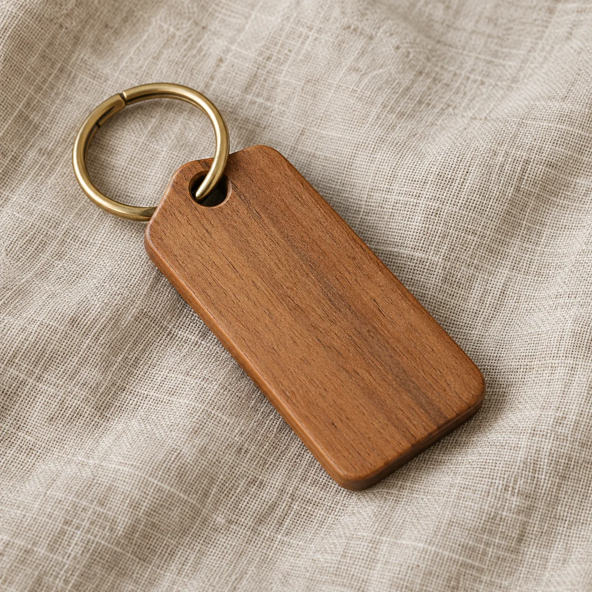 A walnut key fob on a brass ring resting on linen